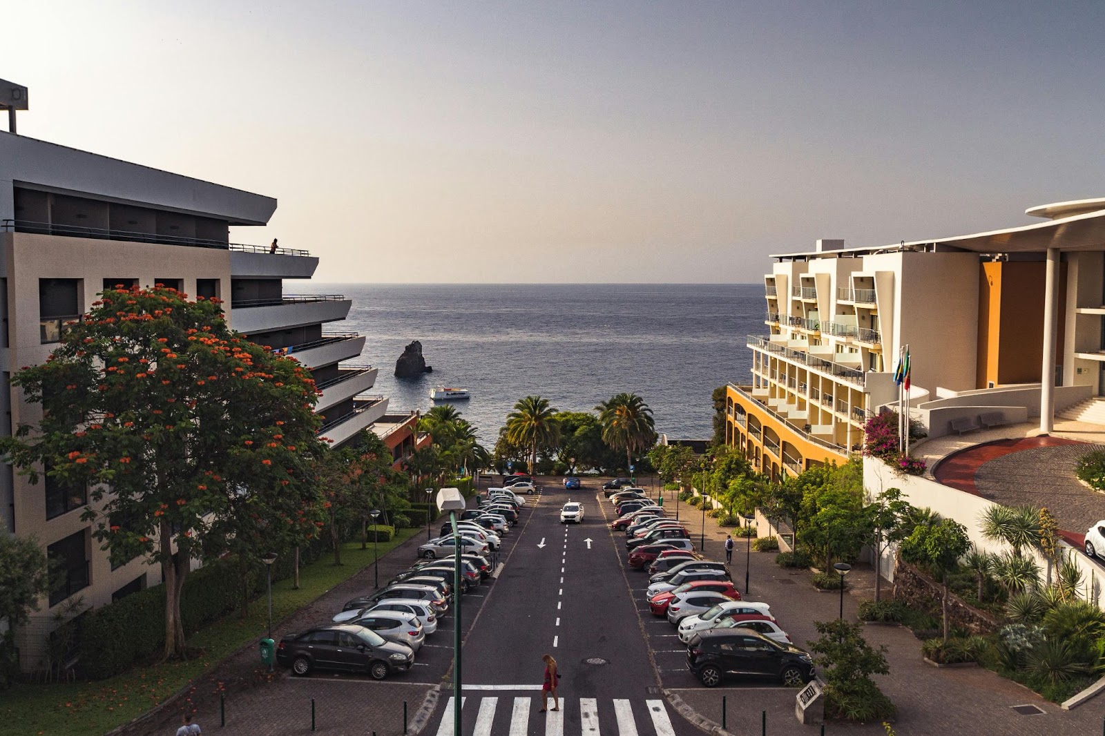 Coastal view with modern buildings and parked cars leading to the sea in Madeira.