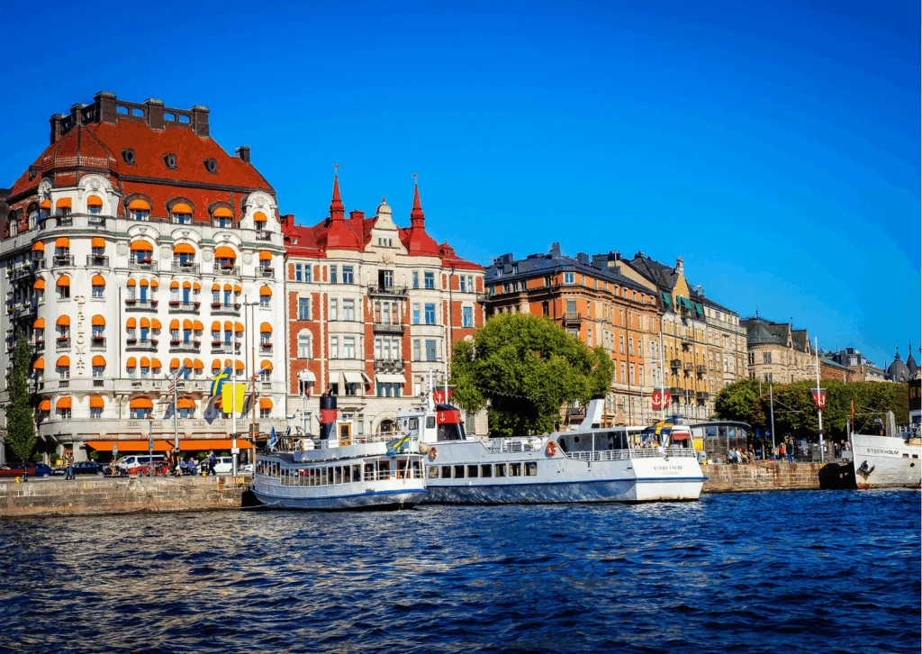 Image of a harbour in Sweden showing colorful buildings, and boats at sea.
